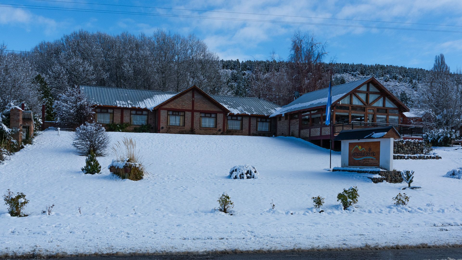 Una casa grande está rodeada de nieve y árboles