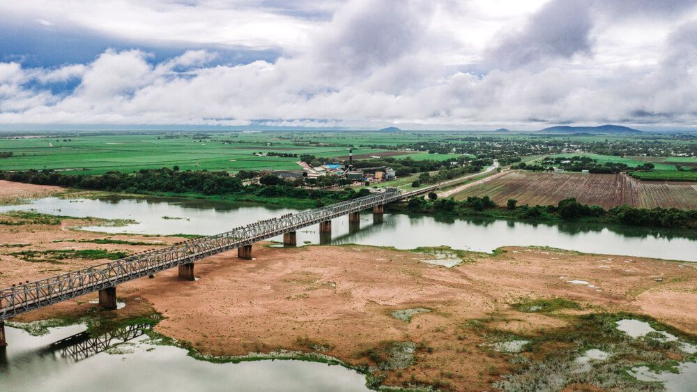 An Aerial View Of A Bridge Over A River Surrounded By Fields — Dieselflash Whitsundays in Ayr, QLD