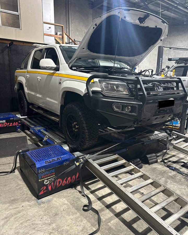 A White Truck With The Hood Open Is Sitting On A Ramp In A Garage — Dieselflash Whitsundays in Bowen, QLD