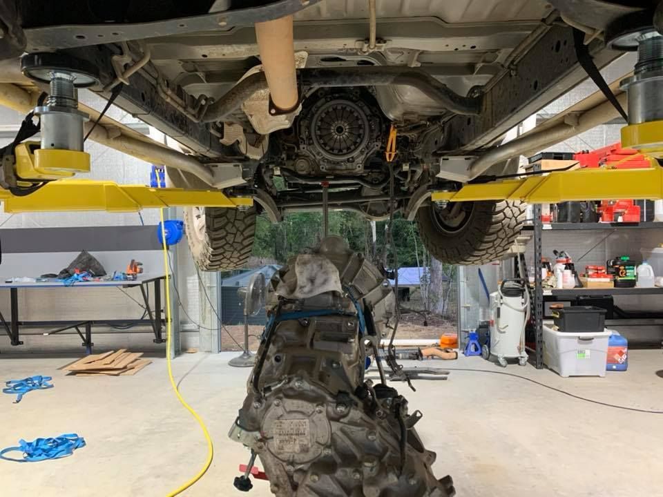 A Car Engine Is Being Removed From Underneath A Truck In A Garage — Dieselflash Whitsundays in Cannonvale, QLD