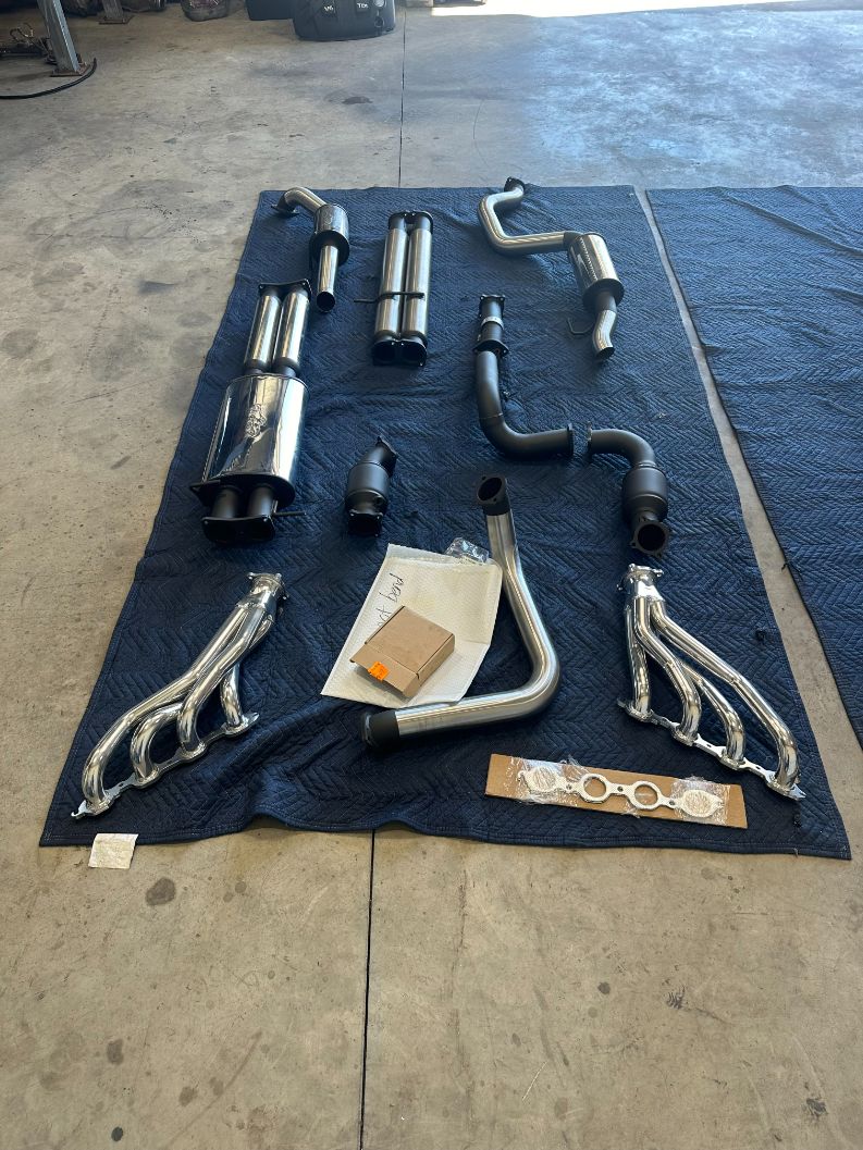 A Bunch of Exhaust Pipes Are Laying on a Blue Mat — Dieselflash Whitsundays in Proserpine, QLD