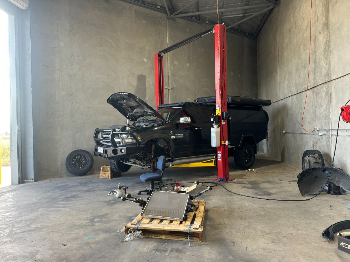 A Black Truck is Sitting on a Lift in a Garage — Dieselflash Whitsundays in Proserpine, QLD