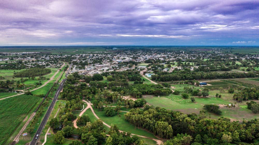 An Aerial View Of A Small Town Surrounded By Trees And Fields — Dieselflash Whitsundays in Ayr, QLD