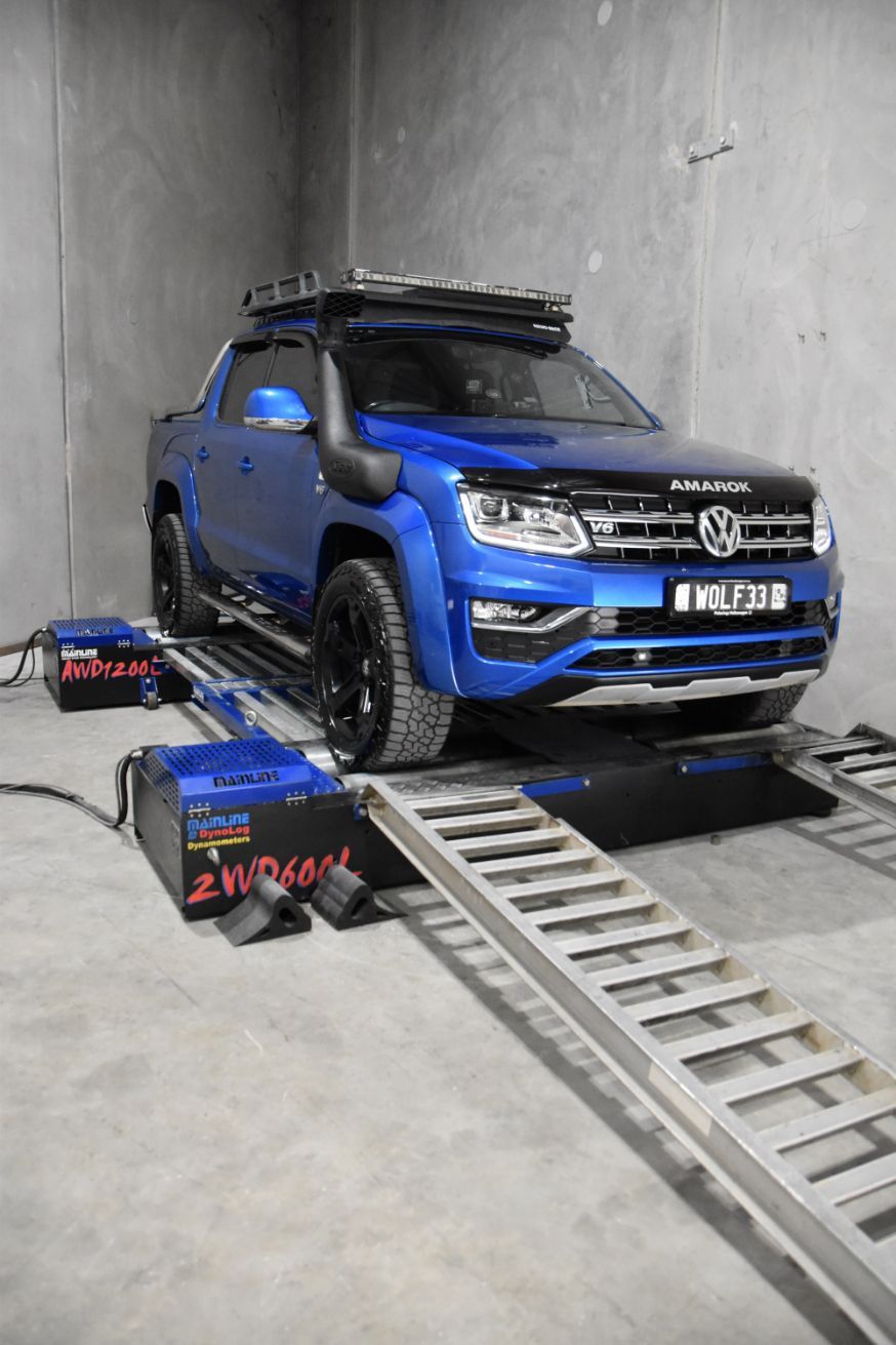 A Blue Volkswagen Amarok is Sitting on a Ramp in a Garage — Dieselflash Whitsundays in Proserpine, QLD