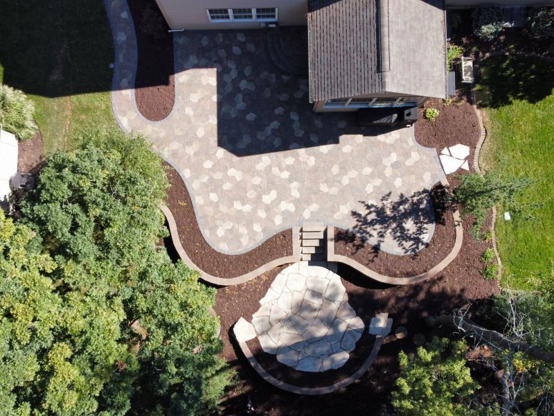 An aerial view of a patio with a house in the background