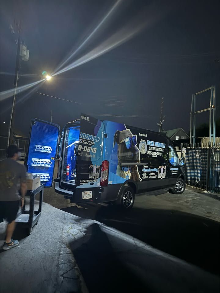 A man in blue overalls is standing in an office with his arms crossed