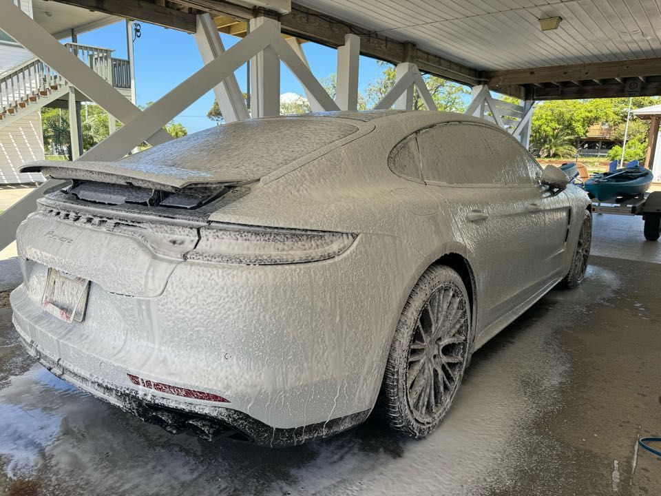 A white air purifier is sitting next to a potted plant.