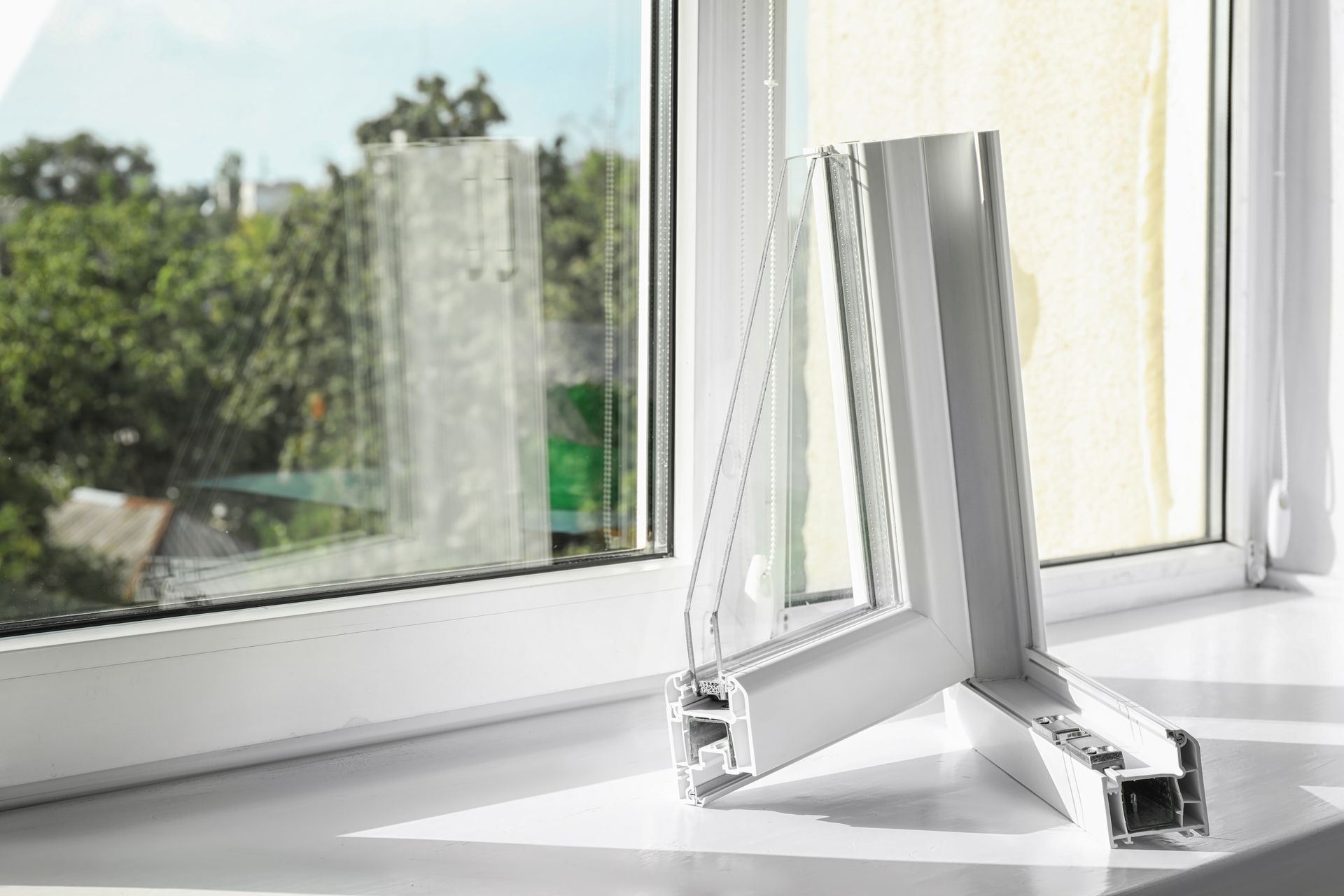 Un cadre de fenêtre en plastique blanc est posé sur un rebord de fenêtre.