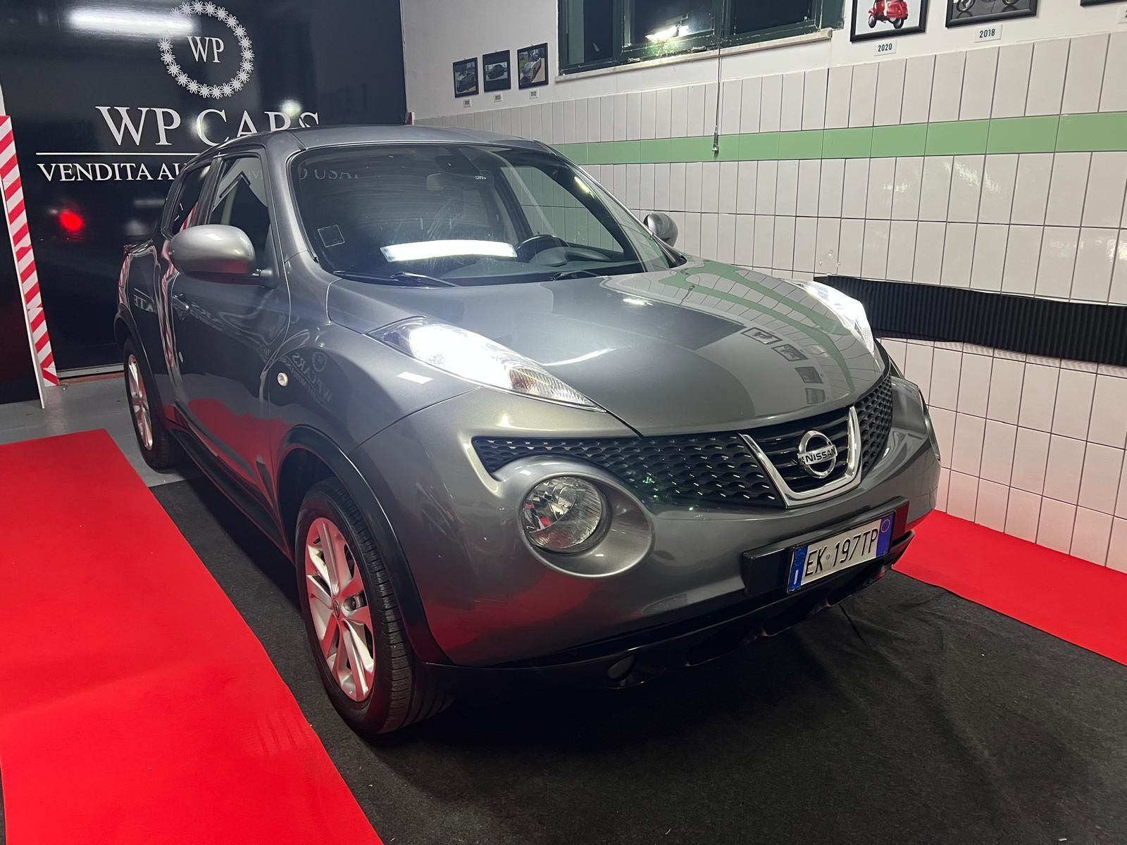 SUV Opel Mokka bianco parcheggiato in uno showroom con interni neri e rossi.