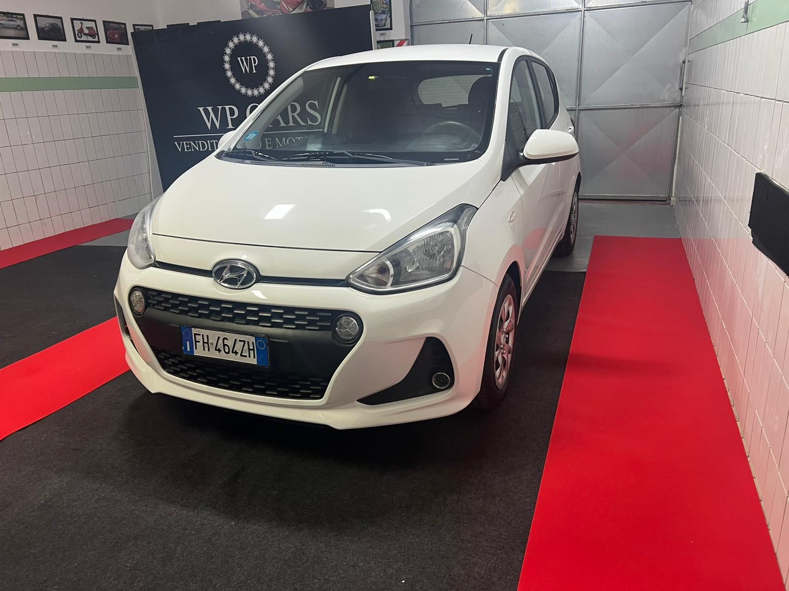 SUV Opel Mokka bianco parcheggiato in uno showroom con interni neri e rossi.
