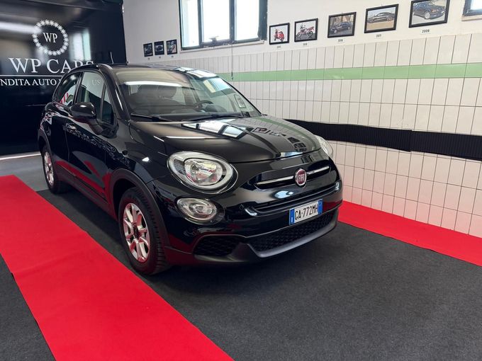 SUV Opel Mokka bianco parcheggiato in uno showroom con interni neri e rossi.