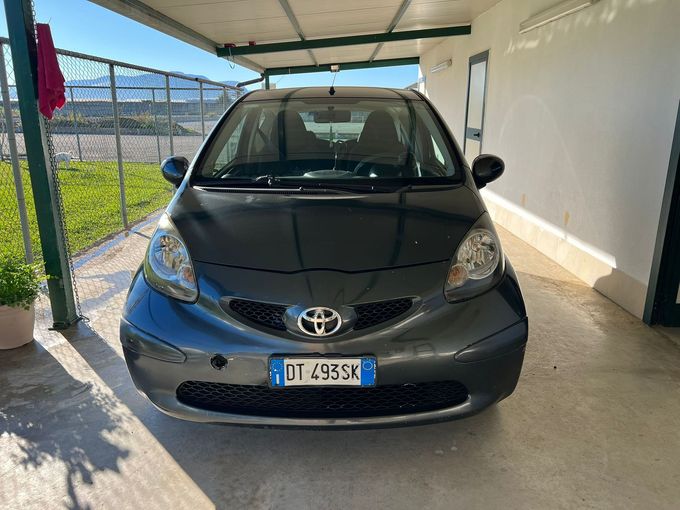 Mercedes-Benz SL argentata in un garage con pavimento nero e rosso, circondata dal marchio VP Cars.