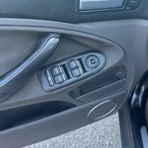 Pannello della portiera dell'auto con comandi per finestrini e specchietti.