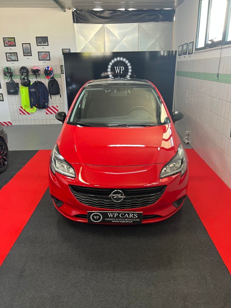 Opel Corsa rossa parcheggiata in un garage.