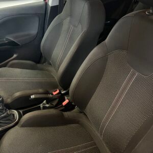 Sedili anteriori neri dell'auto con cuciture rosse, angolati verso l'osservatore.