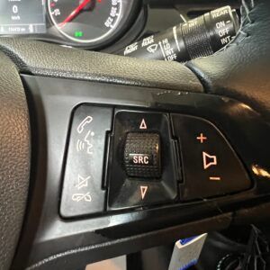 Comandi al volante di un'auto. Include pulsanti per il volume, il telefono e la selezione dei contenuti multimediali.