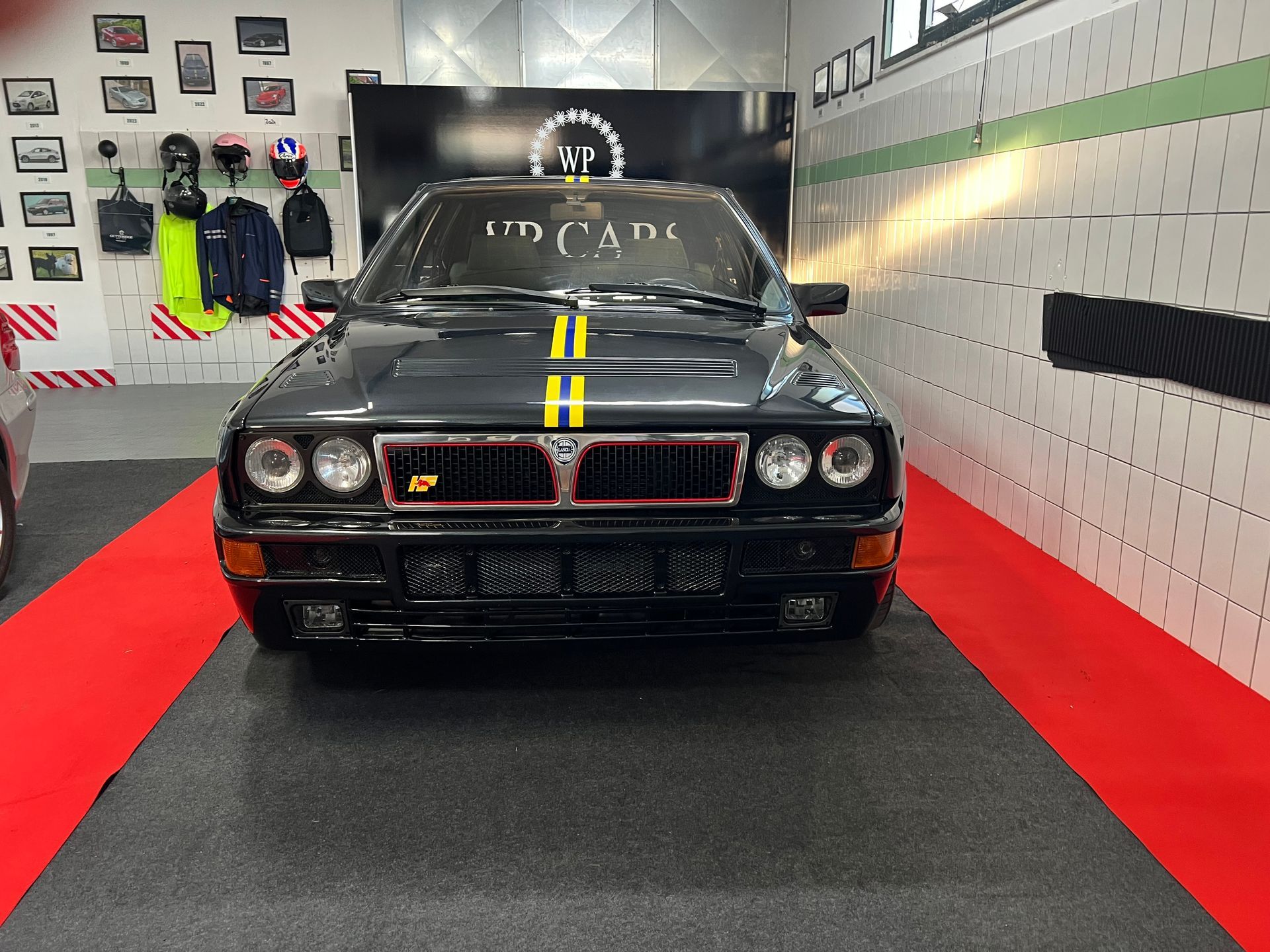 Mercedes-Benz SL argentata in un garage con pavimento nero e rosso, circondata dal marchio VP Cars.