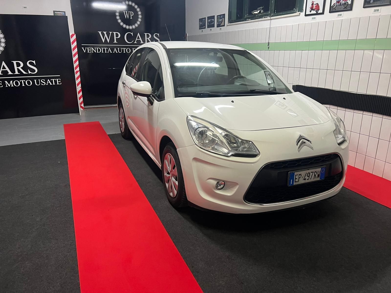 SUV Opel Mokka bianco parcheggiato in uno showroom con interni neri e rossi.