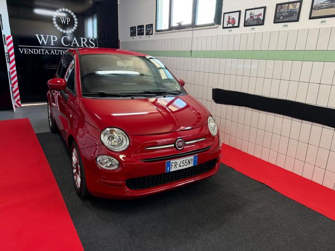 SUV Opel Mokka bianco parcheggiato in uno showroom con interni neri e rossi.