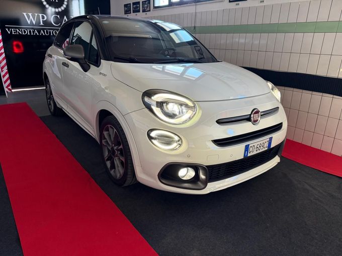 SUV Opel Mokka bianco parcheggiato in uno showroom con interni neri e rossi.