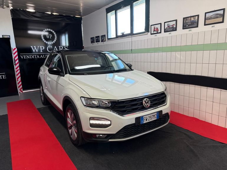 SUV Opel Mokka bianco parcheggiato in uno showroom con interni neri e rossi.