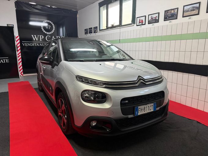 SUV Opel Mokka bianco parcheggiato in uno showroom con interni neri e rossi.