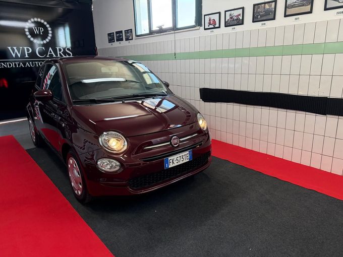 SUV Opel Mokka bianco parcheggiato in uno showroom con interni neri e rossi.