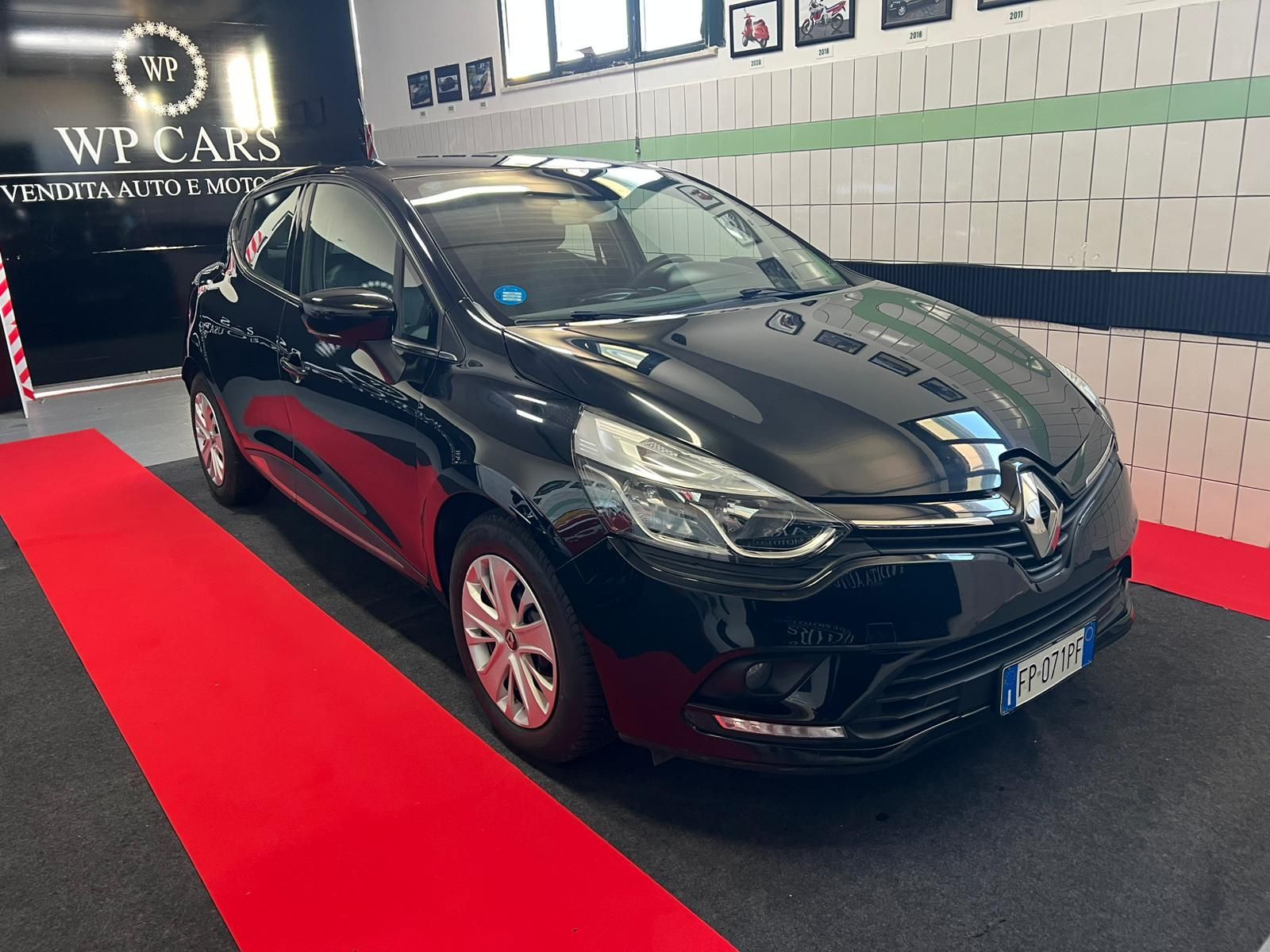 SUV Opel Mokka bianco parcheggiato in uno showroom con interni neri e rossi.