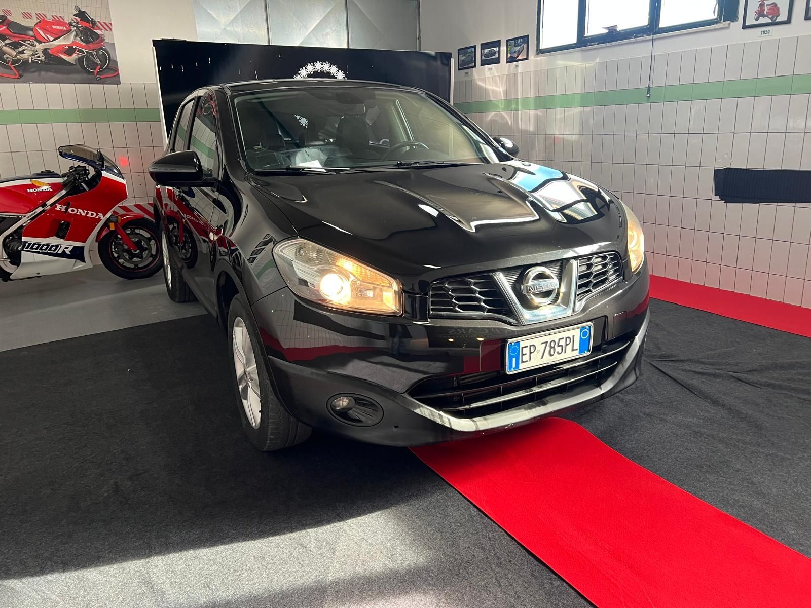 SUV Opel Mokka bianco parcheggiato in uno showroom con interni neri e rossi.
