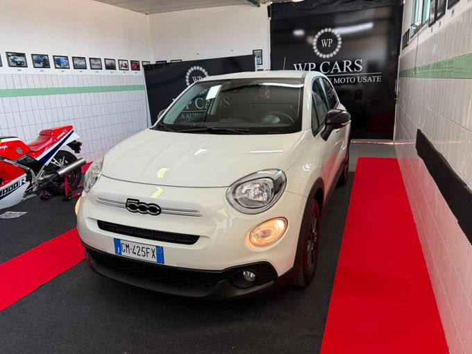 SUV Opel Mokka bianco parcheggiato in uno showroom con interni neri e rossi.