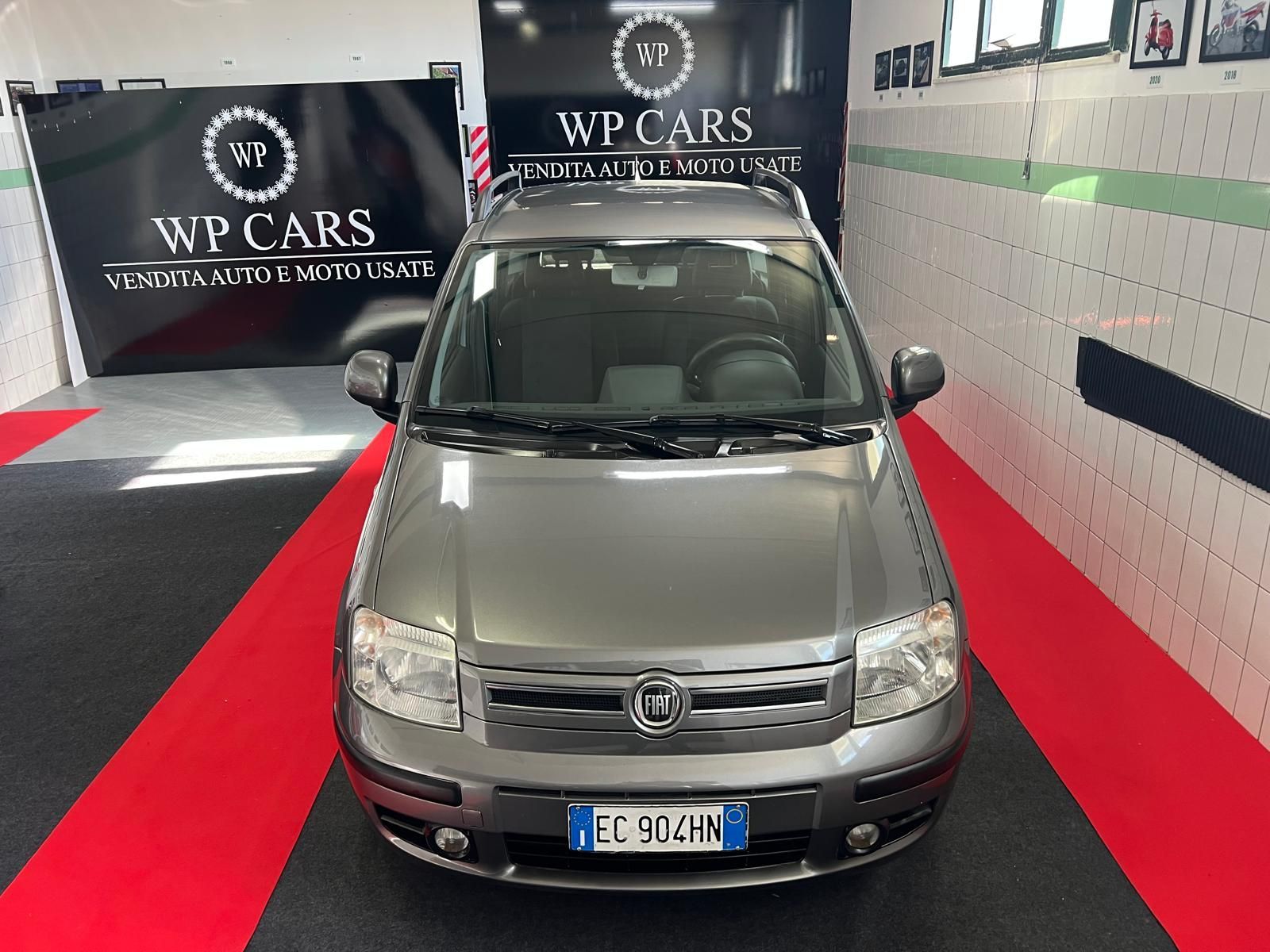 SUV Opel Mokka bianco parcheggiato in uno showroom con interni neri e rossi.