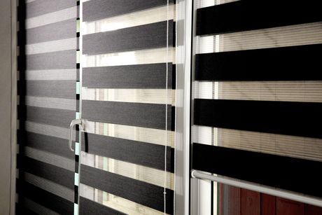 a pair of black and white striped shades on a window All Window Decor (817) 448-3393.