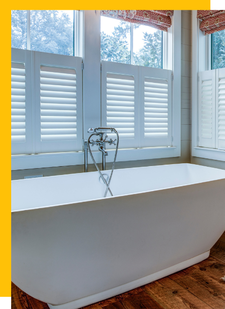 there is a bathtub in the bathroom with shutters on the windows All Window Decor (817) 448-3393.