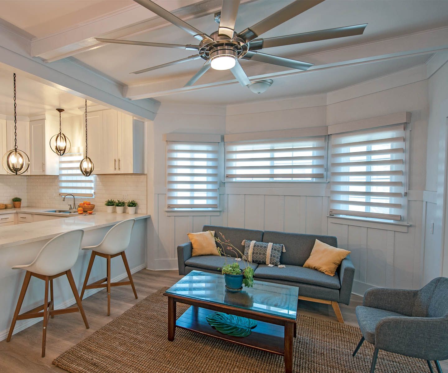 a living room with a couch , table , chairs and a ceiling fan dual shades All Window Decor (817) 448-3393.