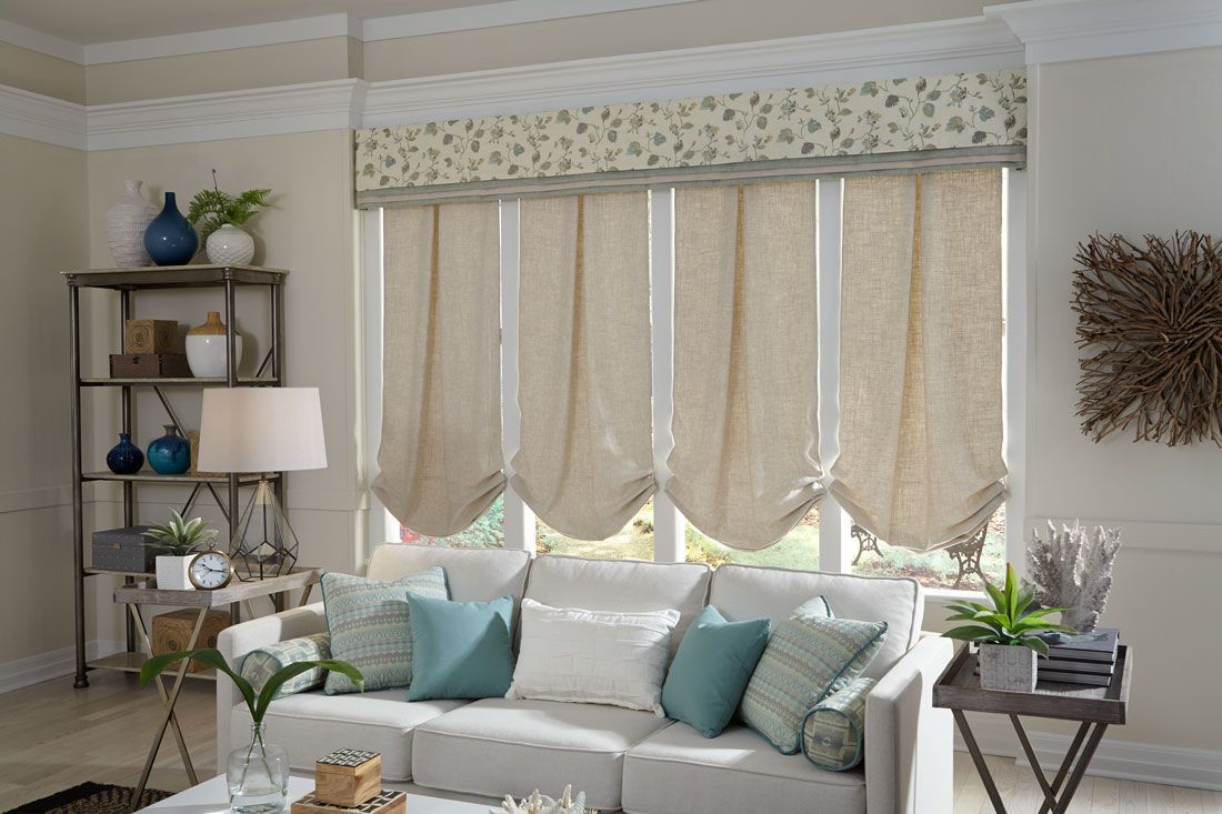 a living room with a white couch and blue pillows and shades with a valance All Window Decor (817) 448-3393