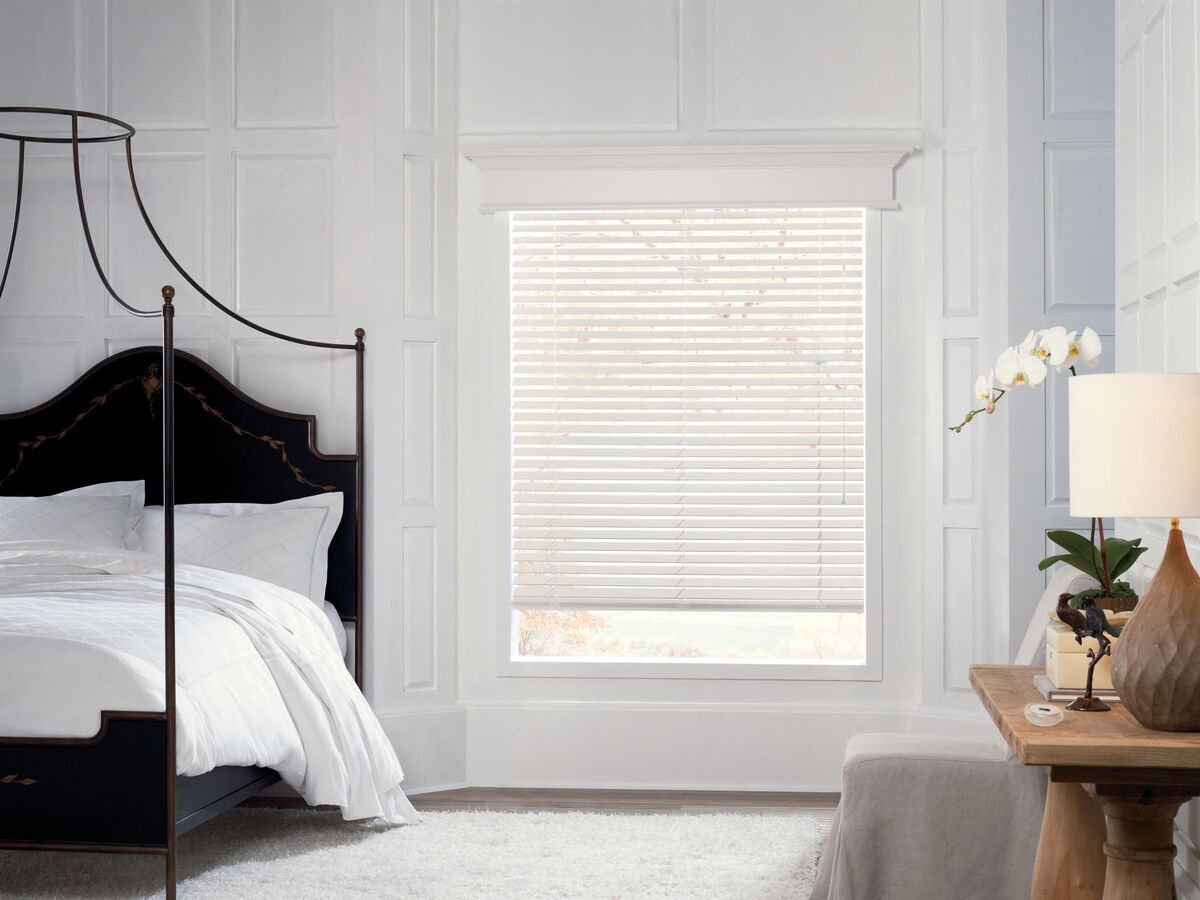 a bedroom with a canopy bed and a window with real wood blinds All Window Decor (817) 448-3393.