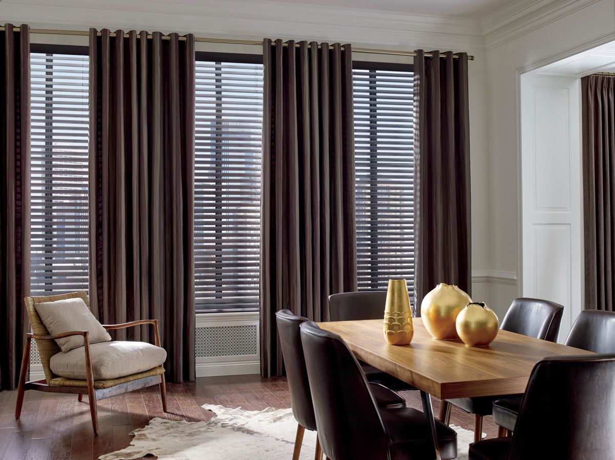 a dining room with a wooden table , chairs , vases and curtains and real wood blinds All Window Decor (817) 448-3393.