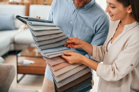 a man and a woman are looking at fabric samples in a living room All Window Decor (817) 448-3393.