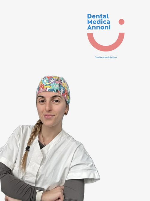 Un professionista del settore dentale, con indosso una cuffia chirurgica a fantasia e una tunica bianca, è ritratto su uno sfondo bianco con il logo di uno studio dentistico.