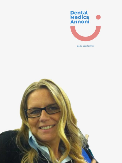 Un professionista sorridente, con gli occhiali, è posizionato sotto il logo di Dental Medica Annoni su sfondo bianco.