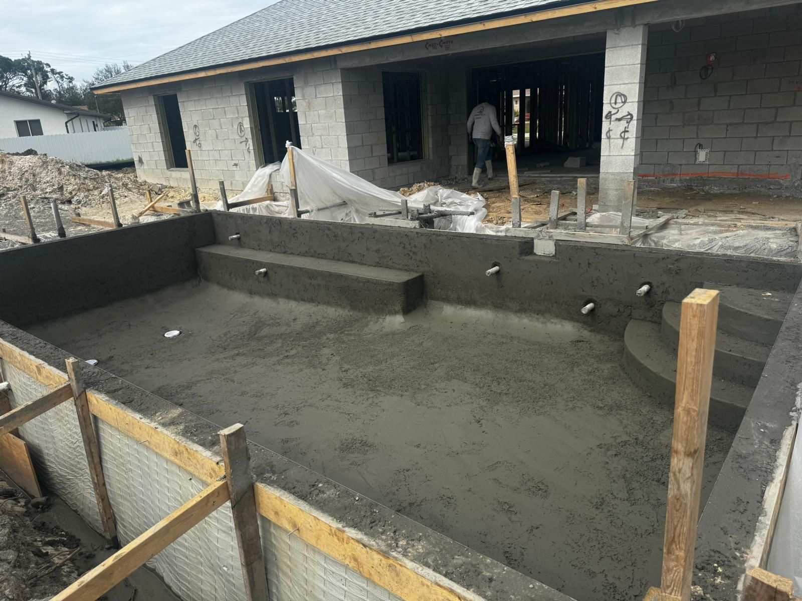 a swimming pool is being built in front of a house .