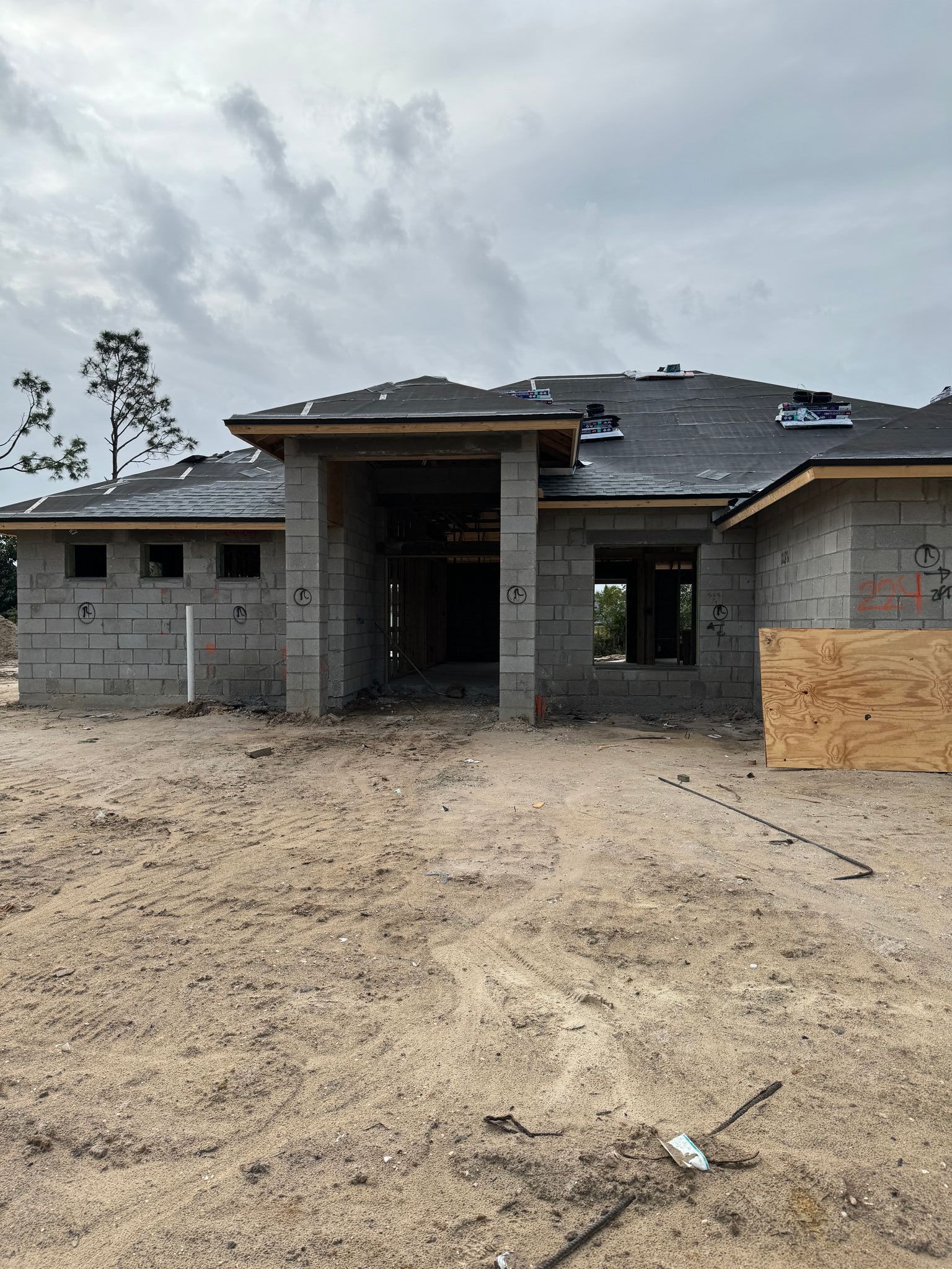a house is being built in the middle of a dirt field .