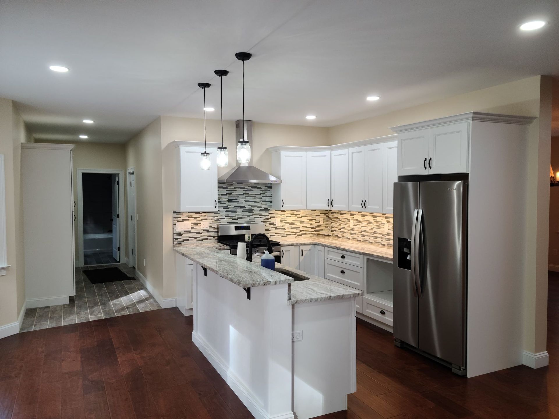 a kitchen with white cabinets and a stainless steel refrigerator .