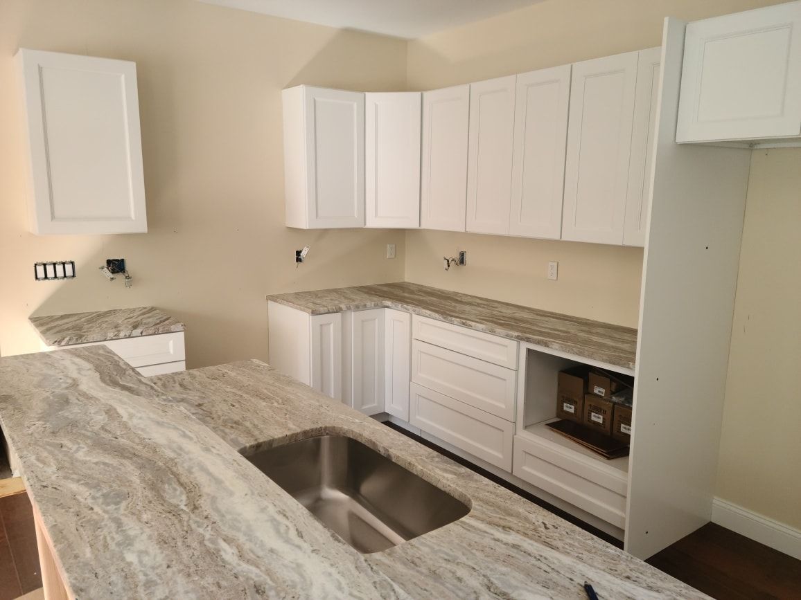 a kitchen with granite counter tops and white cabinets