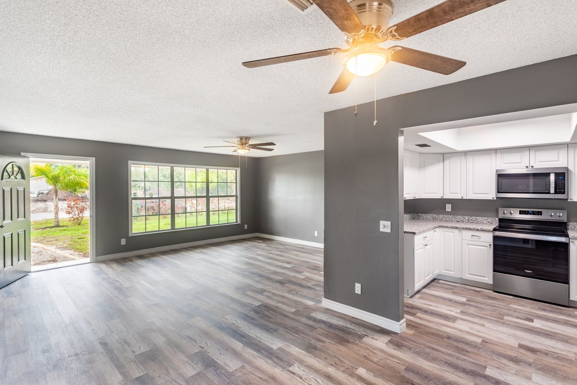 there is a ceiling fan in the living room and a kitchen .