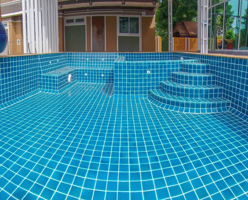 A Pool With Blue Tiles And Stairs — Diverse Poolcare–Pool Fence Inspections & Compliance Certificates In Wagga Wagga, NSW