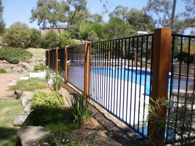 A Metal Fence Surrounds A Pool — Diverse Poolcare–Pool Fence Inspections & Compliance Certificates In West Wodonga, VIC
