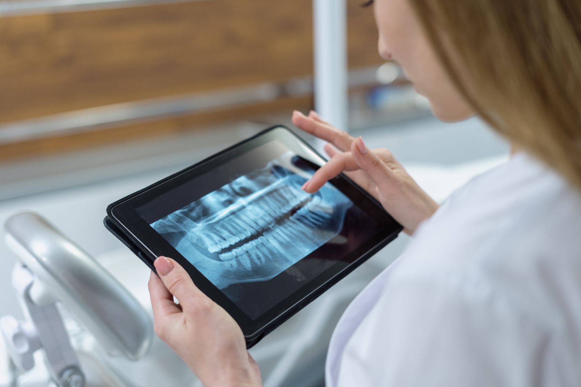 a woman is looking at an x-ray of her teeth on a tablet