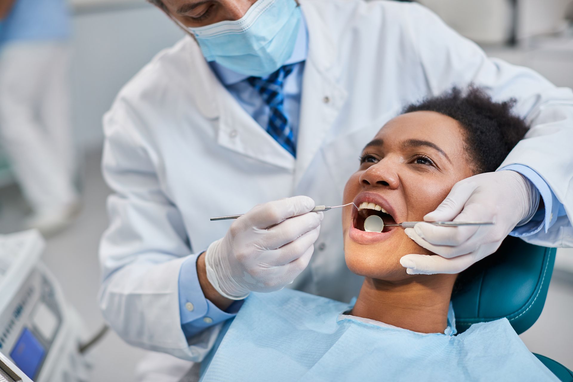 a woman is getting her teeth examined by a dentist