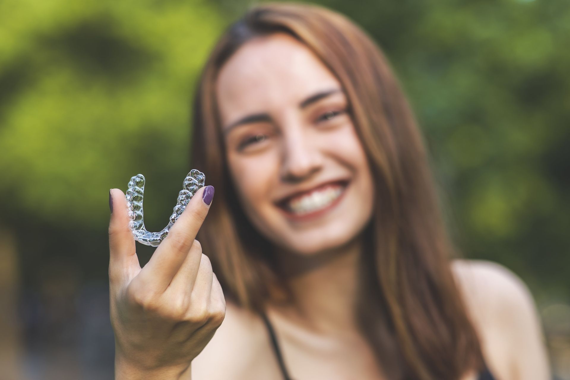 young woman holding invisalign